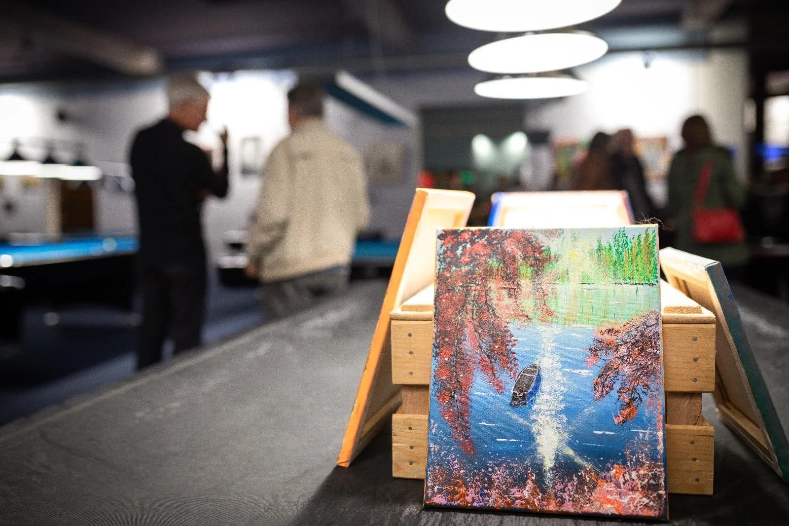 Vernissage im Benteli's – Leinwände im Vordergrund, Besucher im Hintergrund